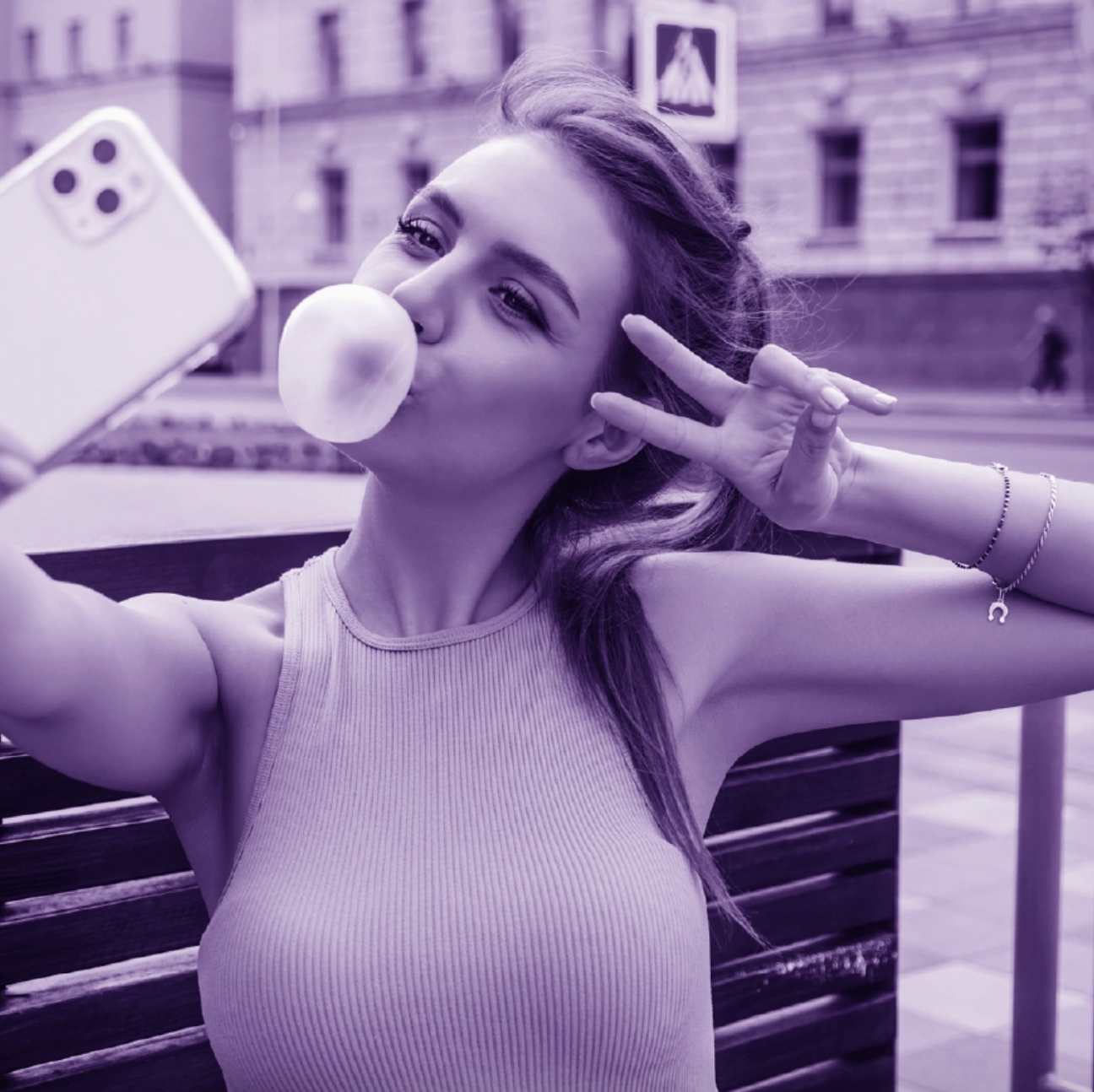 Woman blowing a bubble with gum in an urban setting