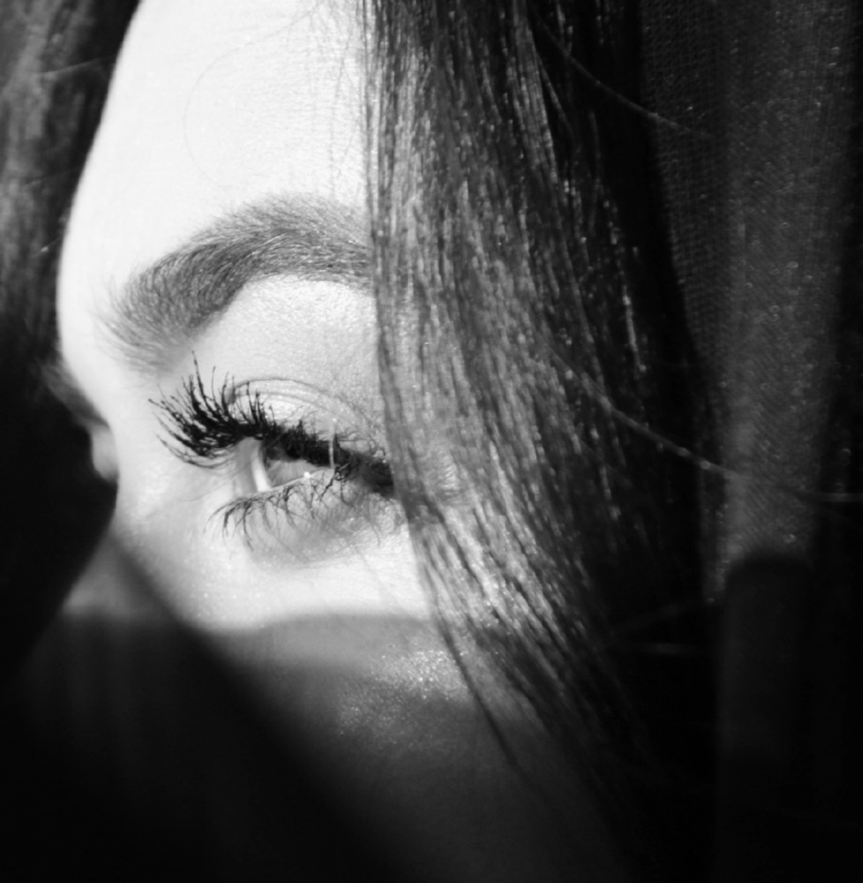 Close-up of a person's eye with dramatic makeup, black and white photo